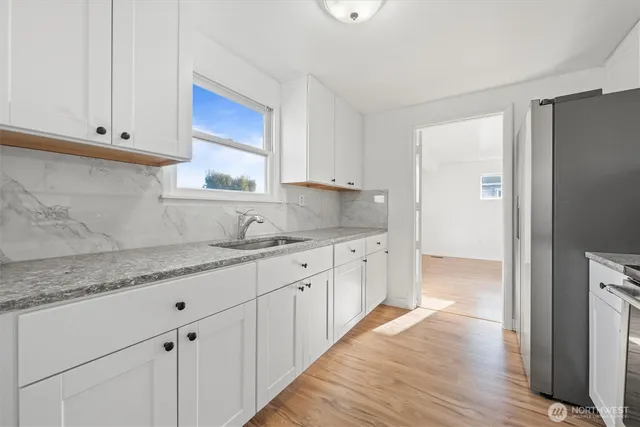 a kitchen with granite countertop white cabinets and sink