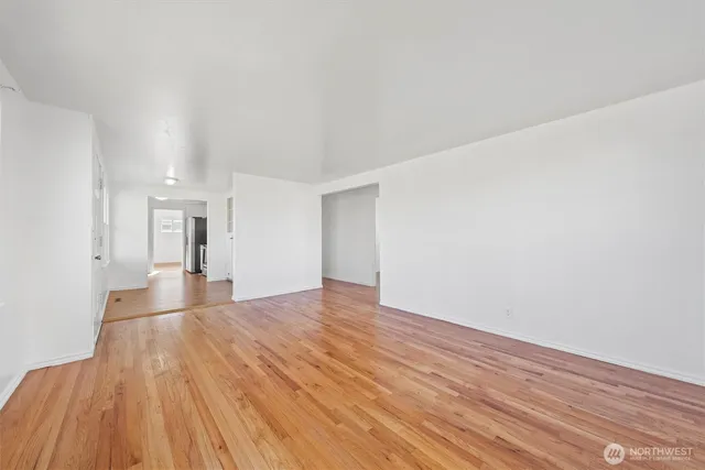 a view of empty room with wooden floor