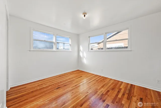 a view of empty room with wooden floor
