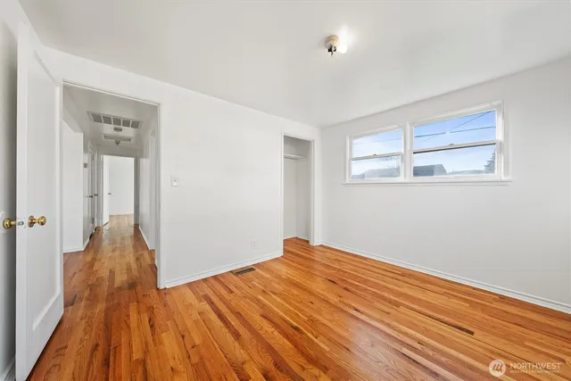 a view of a room with wooden floor and a bathroom
