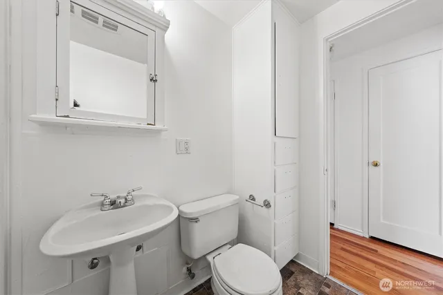 a bathroom with a sink a toilet and a mirror