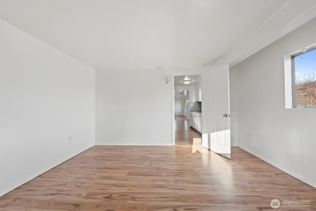 a view of empty room with wooden floor