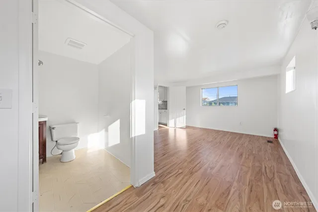 a view of empty room with wooden floor