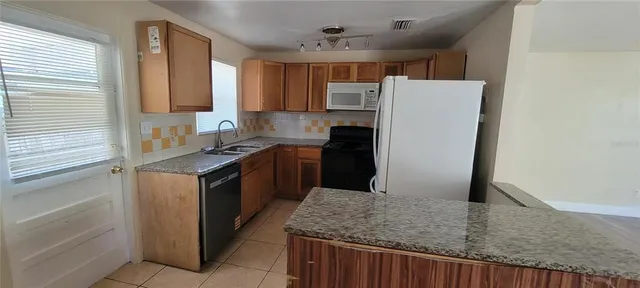 a kitchen with kitchen island sink refrigerator and stove