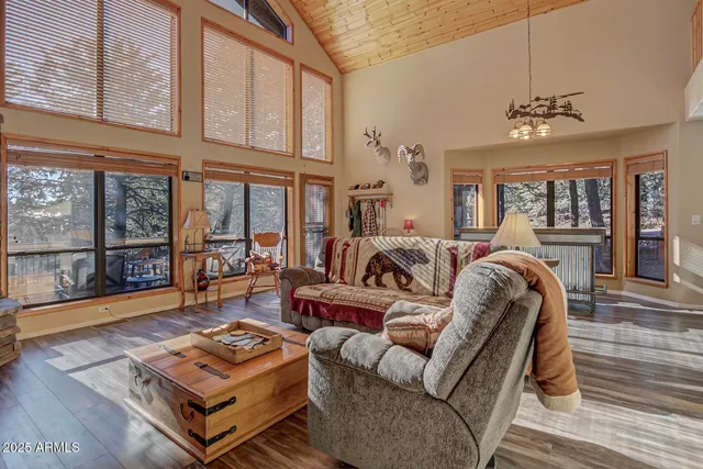 a living room with furniture a flat screen tv and a floor to ceiling window