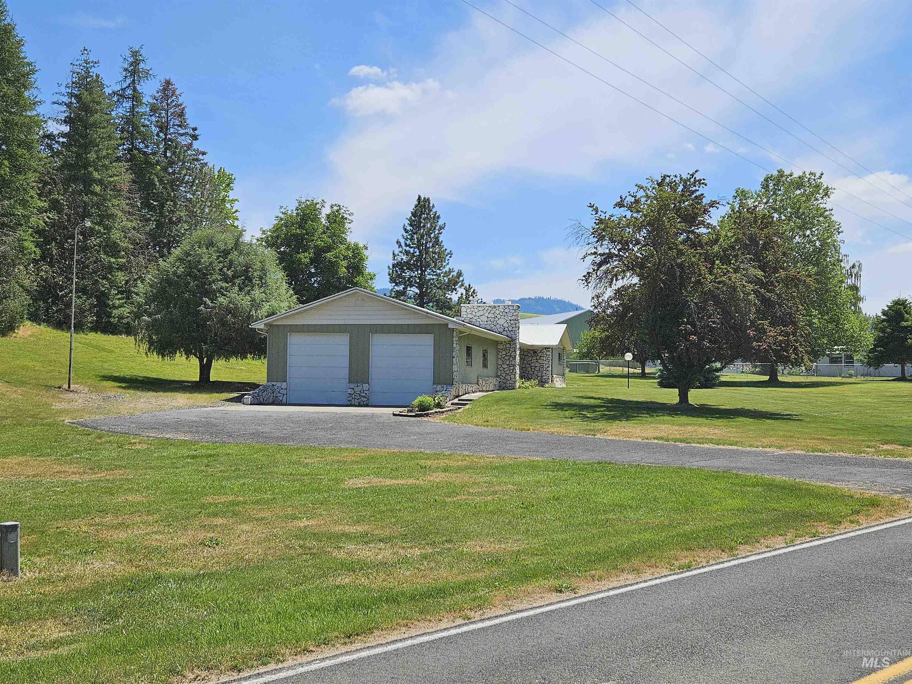 29865 Mission Creek Road Culdesac, ID 83524 - Photo 38 of 43 Single-story residence featuring a two-car garage with white paneled doors and stone accents