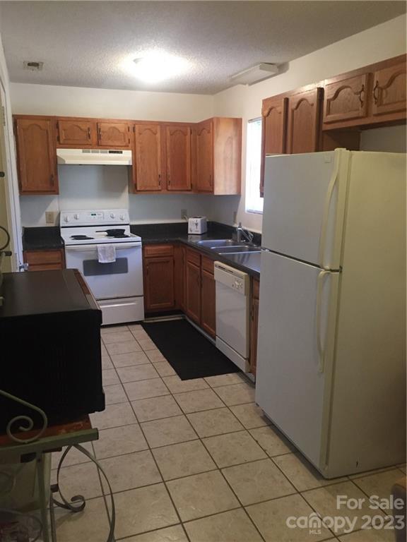 6019 Double Rein Road Charlotte, NC 28215 - Photo 7 of 21 a kitchen with a refrigerator and a stove top oven