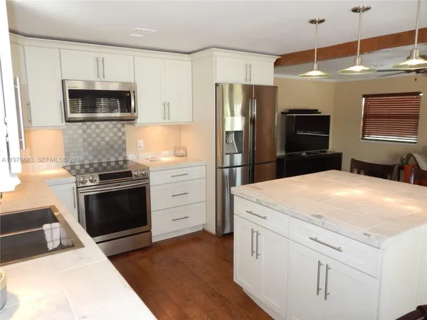 a kitchen with stainless steel appliances a stove microwave and refrigerator