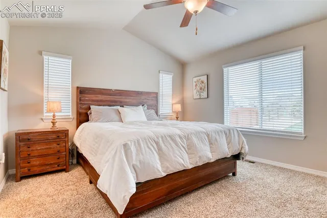 a bed sitting in a bedroom next to a window and a chandelier
