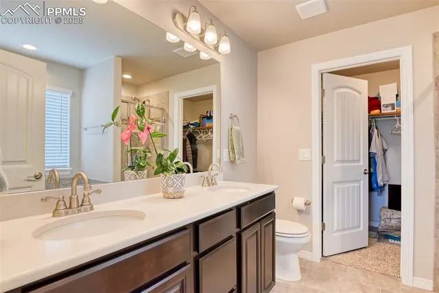 a bathroom with a sink a toilet and a large mirror