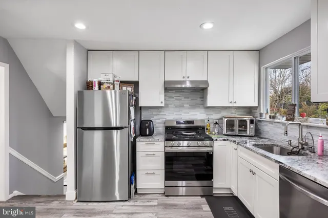 a kitchen with a refrigerator a stove a sink and a window