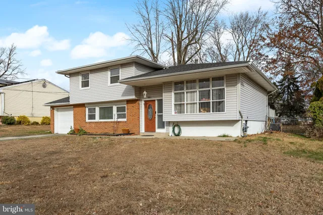 a house that has a tree in front of a white house