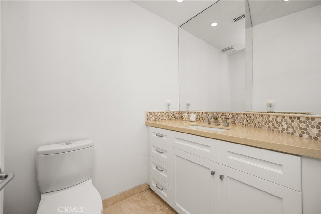 8 Moon Shadow, Unit 8 Irvine, CA 92603 - Photo 28 of 42 a bathroom with a granite countertop sink a toilet and a mirror