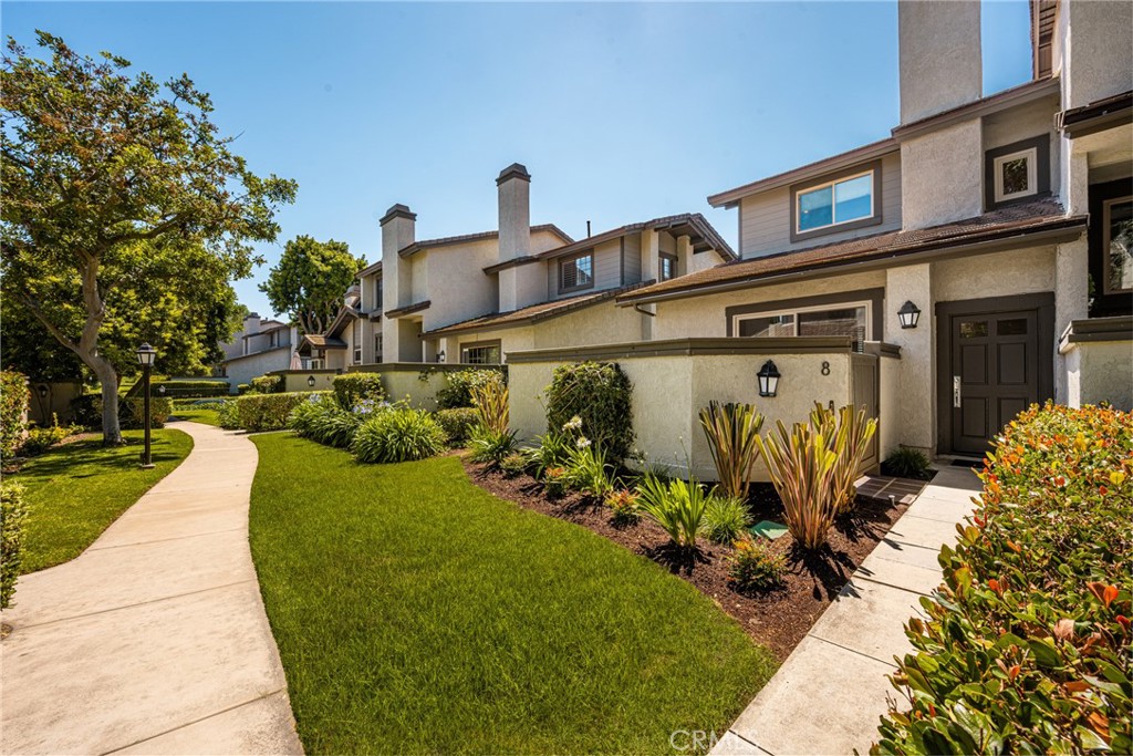 8 Moon Shadow, Unit 8 Irvine, CA 92603 - Photo 3 of 42 a front view of a house with garden
