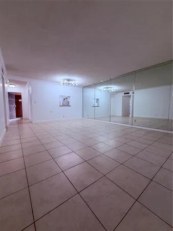 a view of a livingroom with an empty space and a kitchen