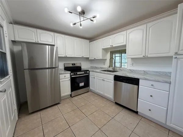 a kitchen with cabinets and stainless steel appliances