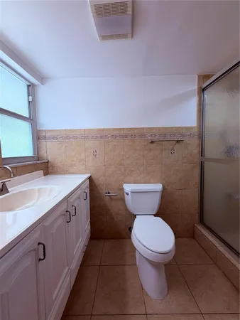 a view of empty room with window and ceiling fan
