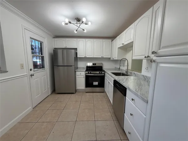 a kitchen with a refrigerator sink and cabinets