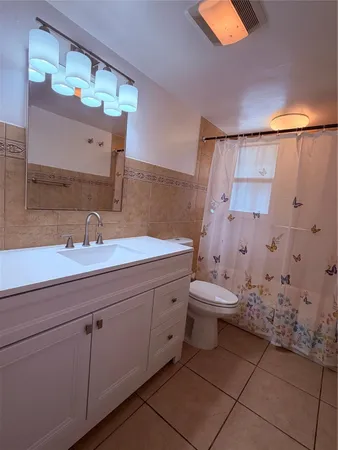 a bathroom with a double vanity sink mirror and toilet