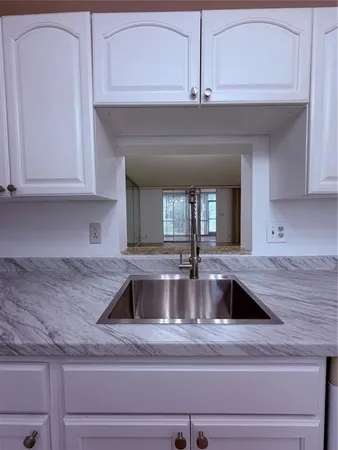 a kitchen with granite countertop a sink and cabinets