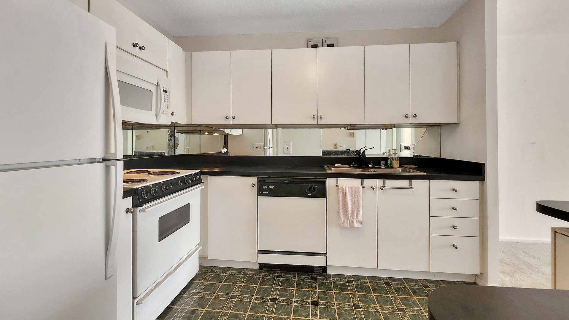 405 North Wabash Avenue, Unit 314 Chicago, IL 60611 - Photo 6 of 26 a kitchen with granite countertop white cabinets and white appliances