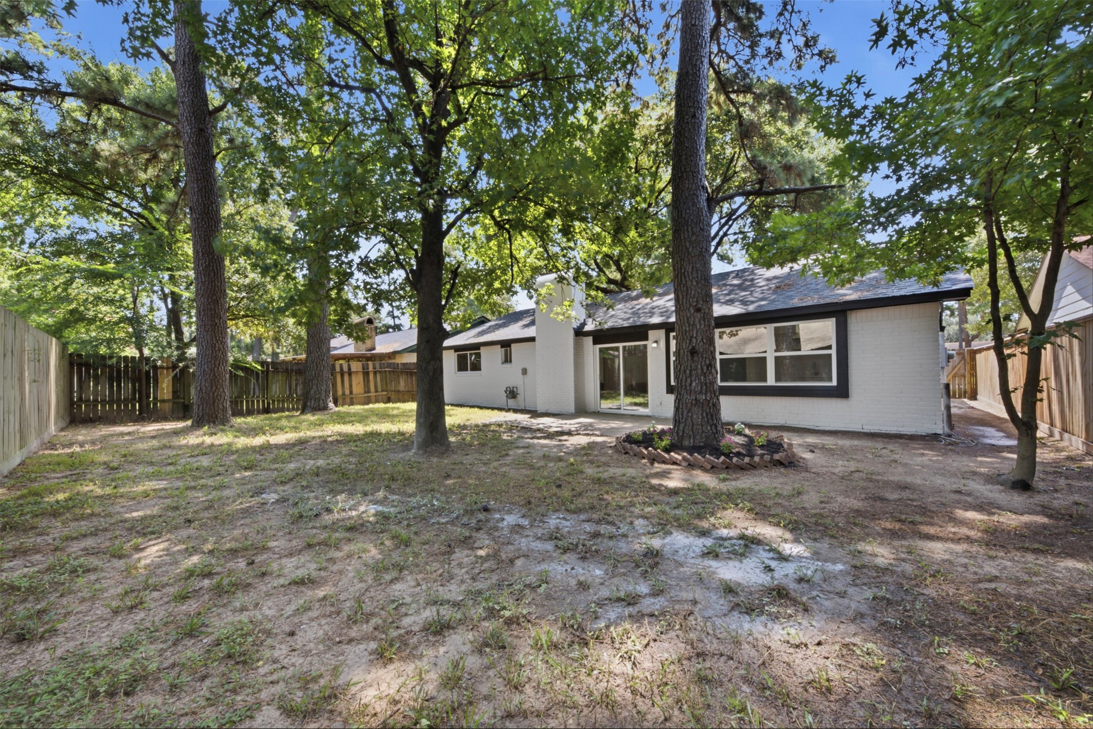 9518 Landry Boulevard Spring, TX 77379 - Photo 27 of 38 Charming single-story home with a spacious fenced backyard, shaded by mature trees and offering a serene outdoor retreat.