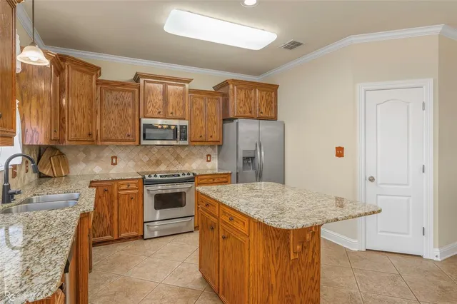 a kitchen with stainless steel appliances granite countertop a stove a sink dishwasher and a refrigerator
