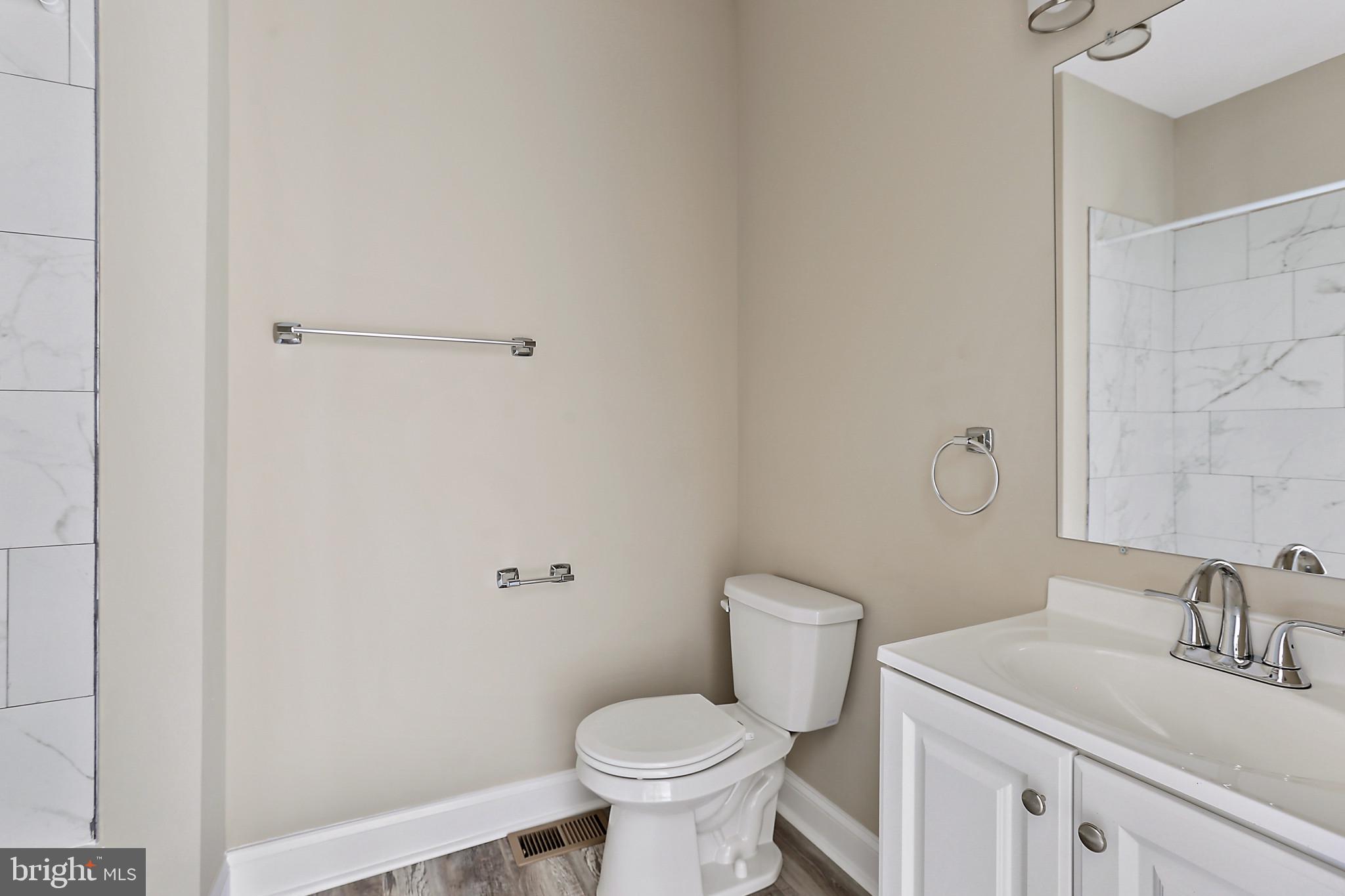 100 Collins Avenue Baltimore, MD 21229 - Photo 13 of 18 a bathroom with a sink toilet and a mirror