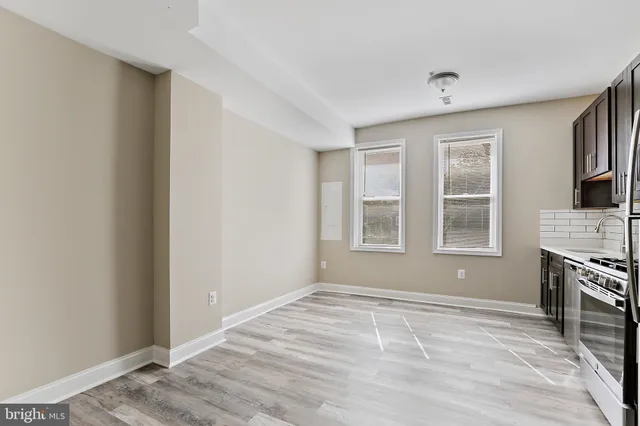 a view of an empty room with a window and fireplace
