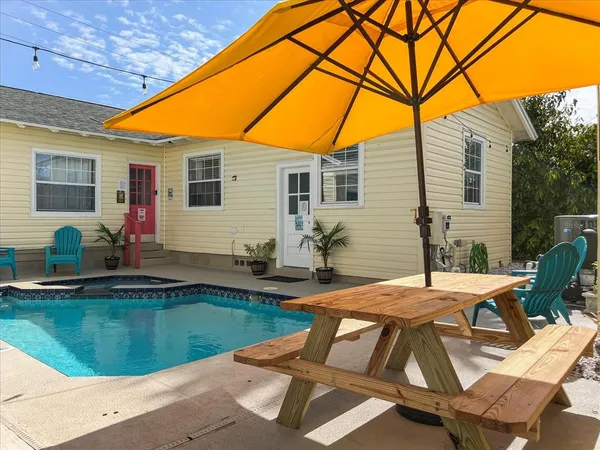 a view of backyard of house with swimming pool outdoor seating