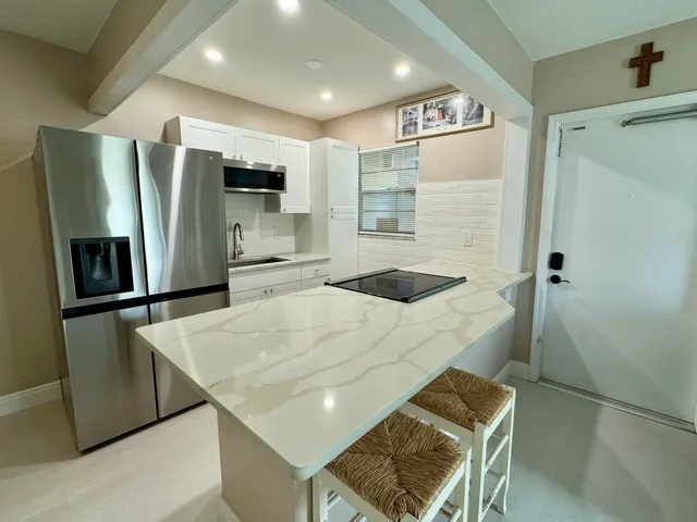 a kitchen with stainless steel appliances a stove a sink and a refrigerator
