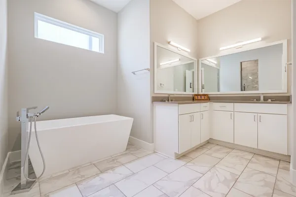 a bathroom with a bathtub sink and mirror