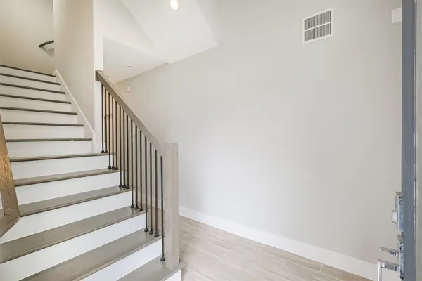 a view of staircase with wooden floor and white walls