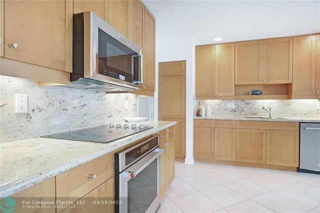 a kitchen with granite countertop a sink stove and cabinets