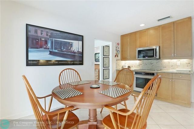 a kitchen with stainless steel appliances granite countertop a dining table and chairs