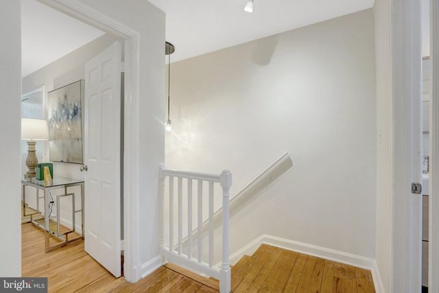 a bedroom with a bed a lamp on dresser and a window