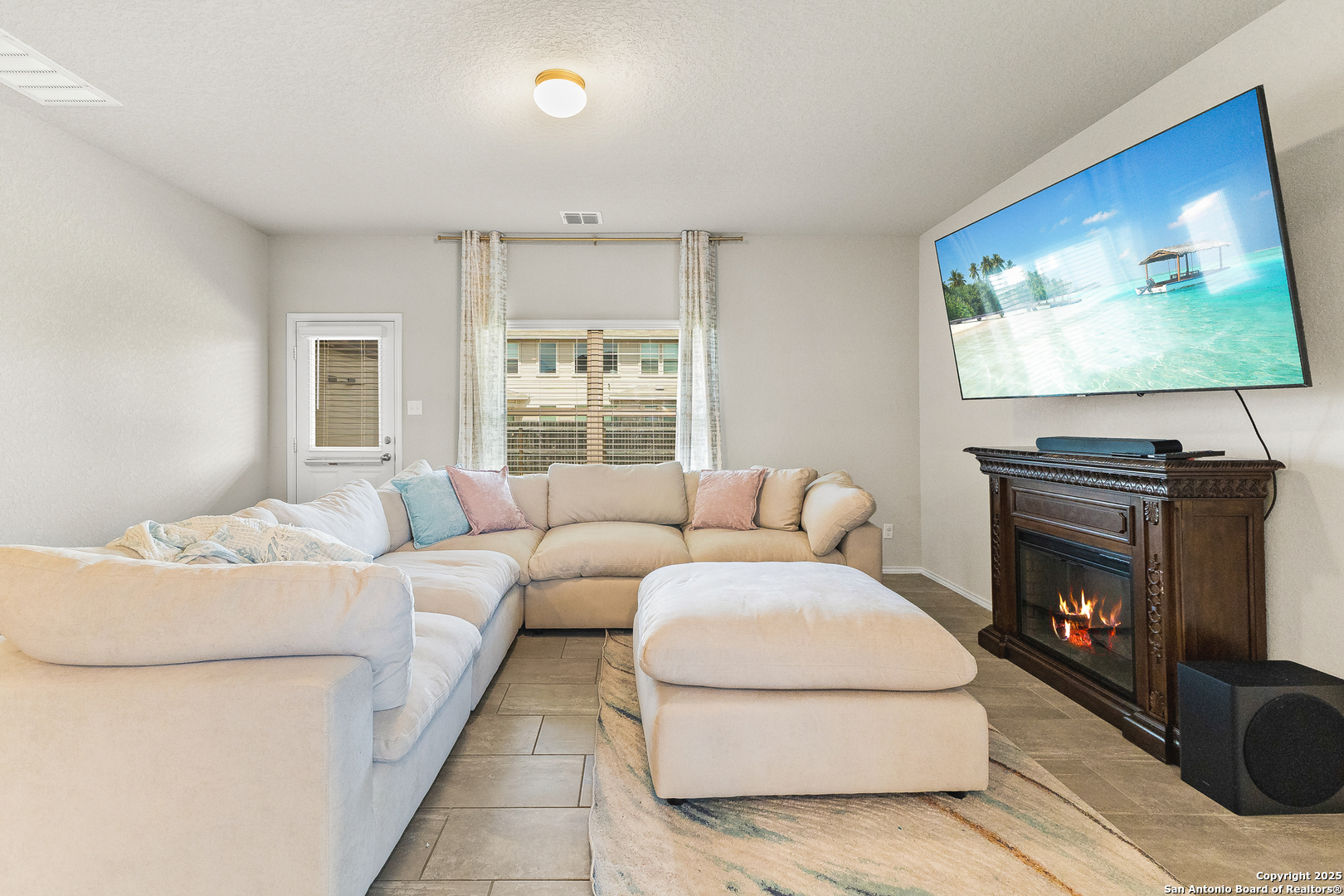 217 Stag Way Cibolo, TX 78108 - Photo 13 of 31 a living room with furniture a fireplace and a flat screen tv