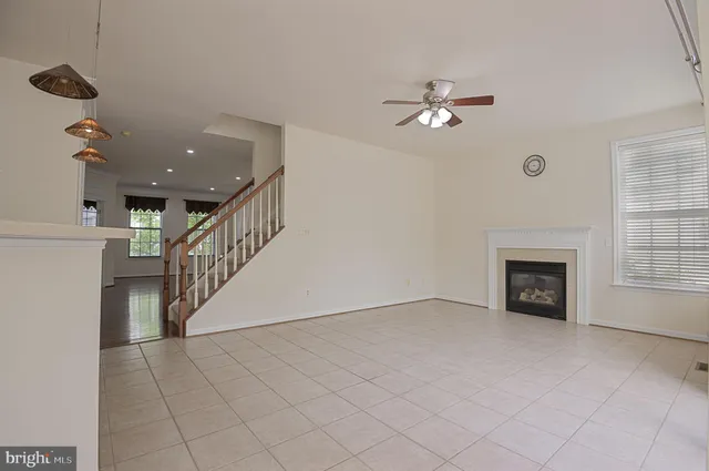an empty room with windows and fireplace