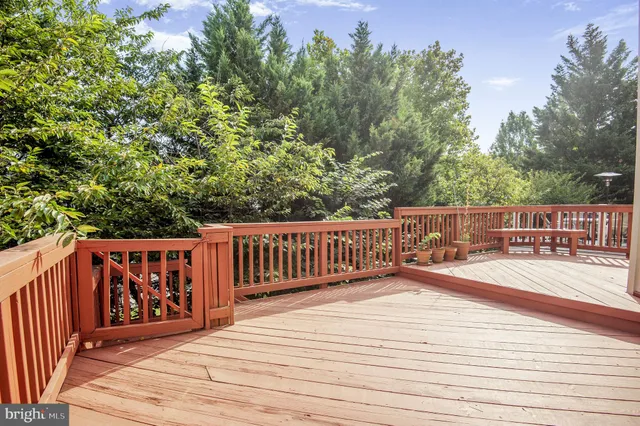 a view of deck with wooden floor and fence and trees