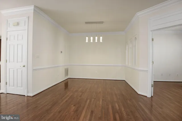 a view of a room with wooden floors and white walls