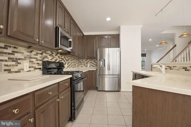 a kitchen with a sink a refrigerator and cabinets