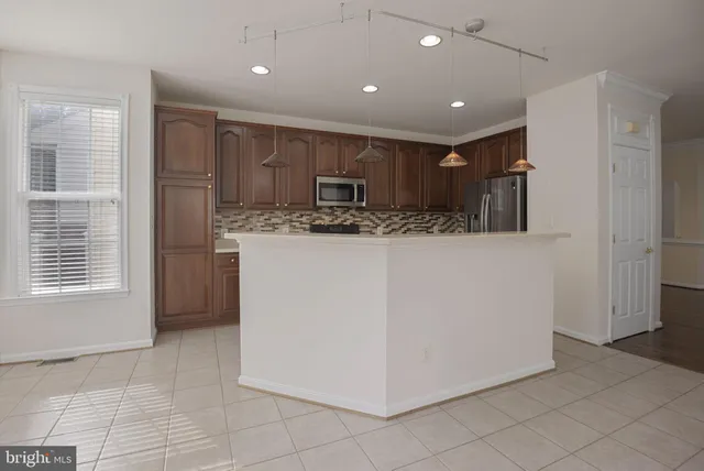 a kitchen with kitchen island a stove a refrigerator a sink and a refrigerator