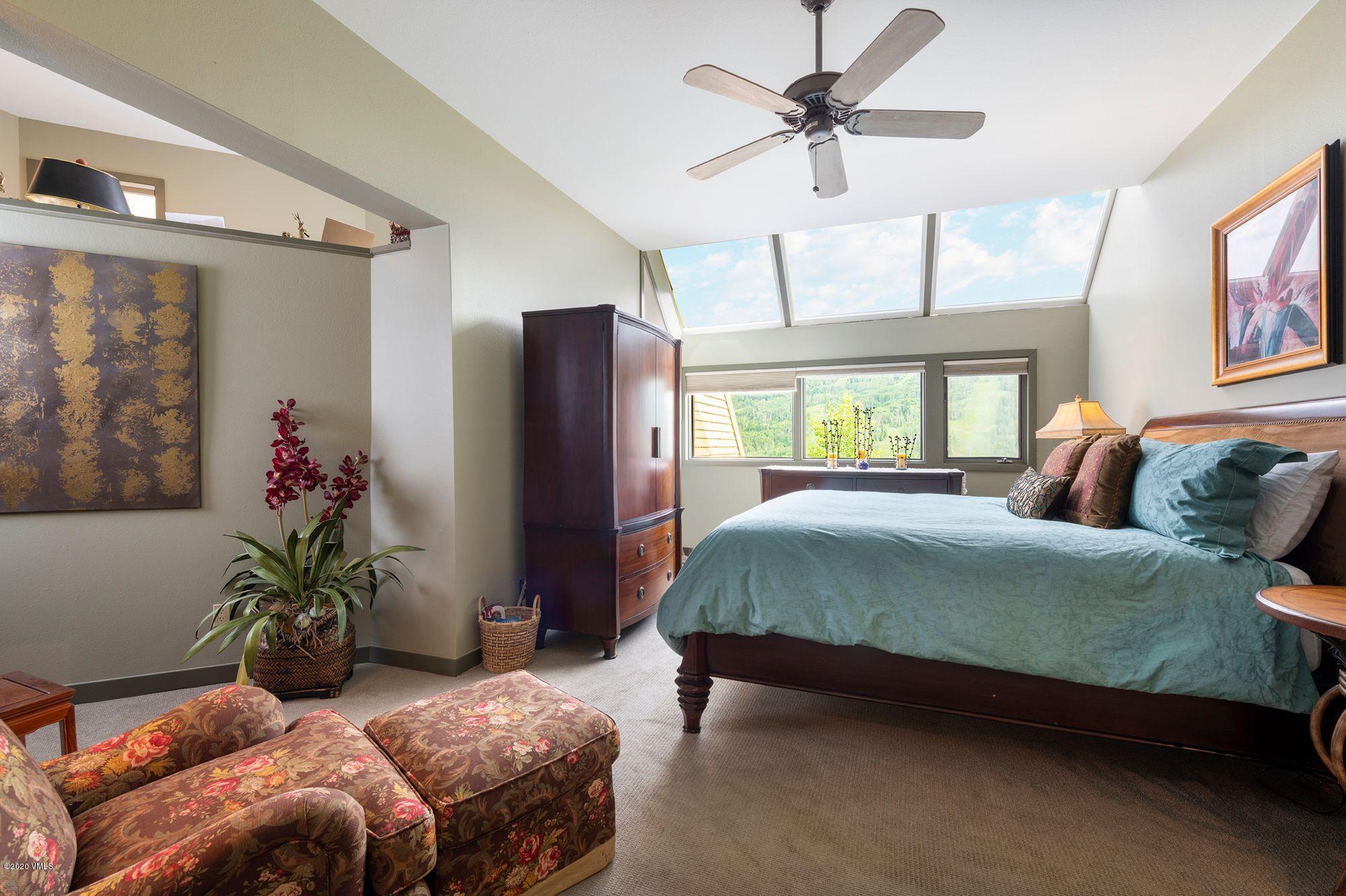 770 Potato Patch Drive, Unit 15 Vail, CO 81657 - Photo 12 of 23 a bedroom with a bed potted plant on a dresser and a large window