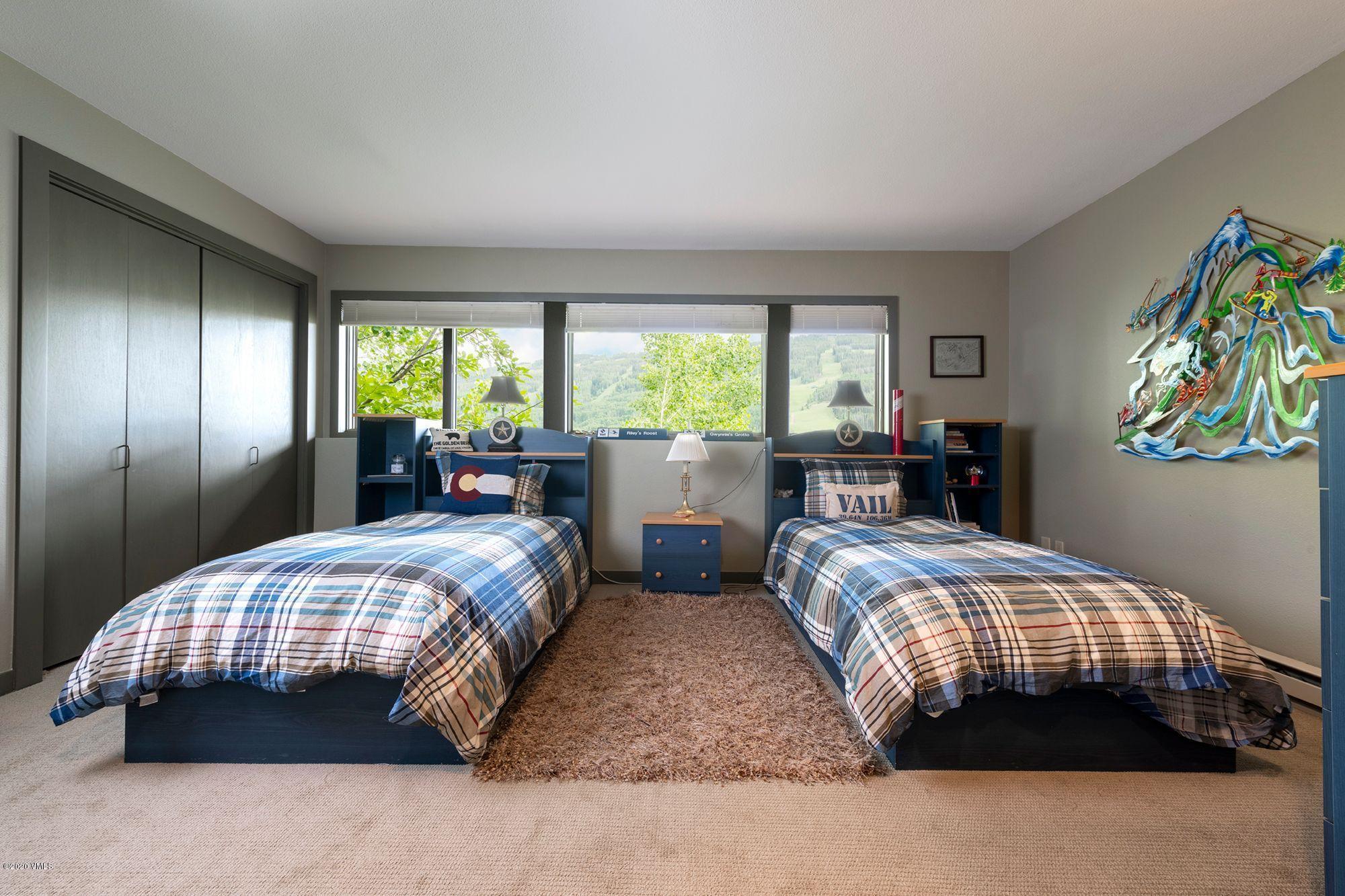 770 Potato Patch Drive, Unit 15 Vail, CO 81657 - Photo 15 of 23 a bedroom with a bed and a chandelier