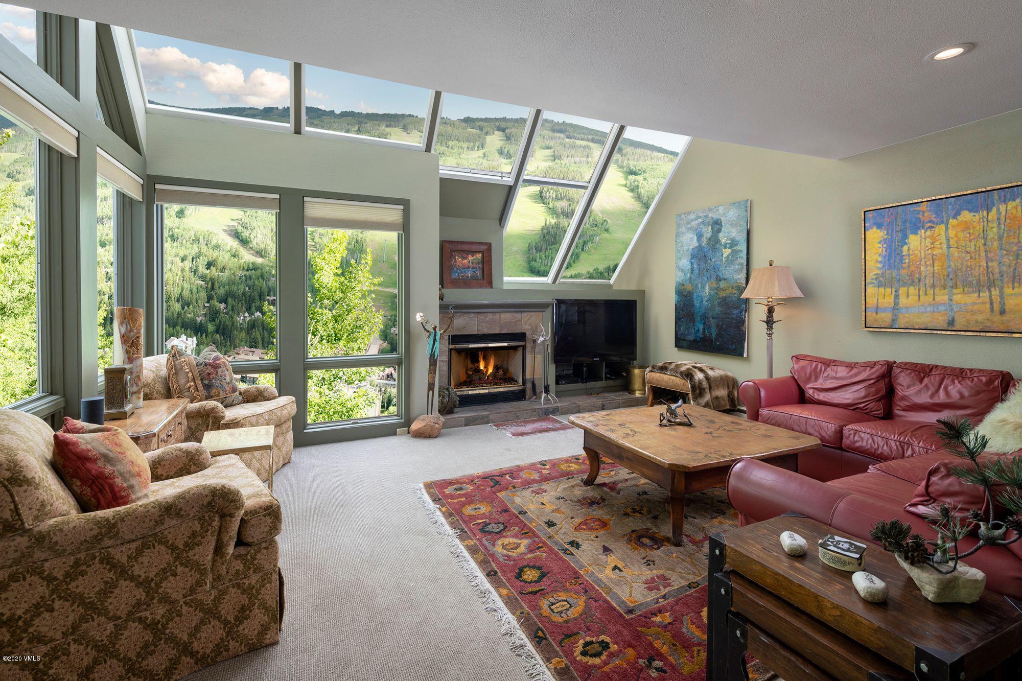 770 Potato Patch Drive, Unit 15 Vail, CO 81657 - Photo 9 of 23 a living room with furniture a fireplace and a large window