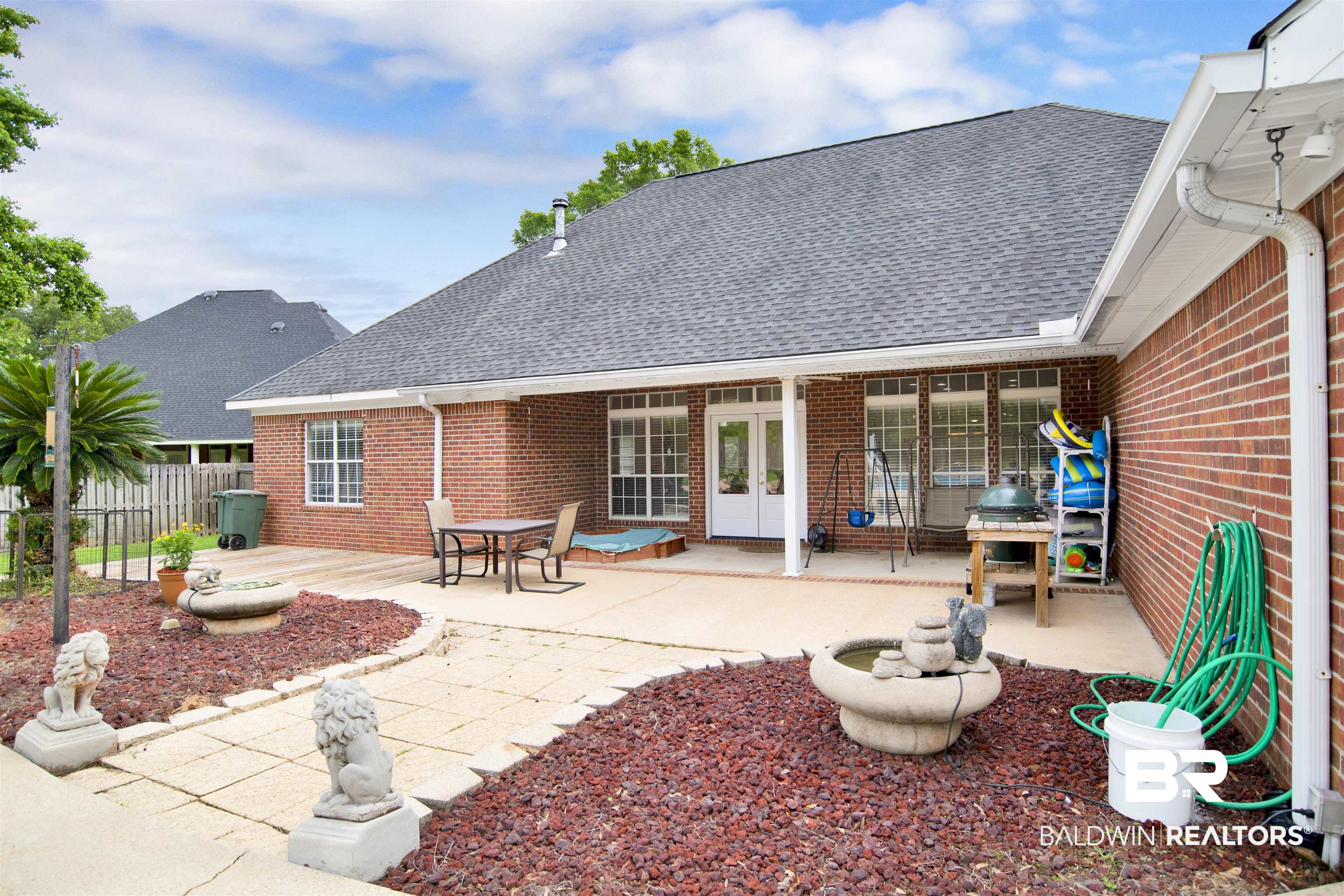 8847 Dawes Lake Road South Mobile, AL 36619 - Photo 41 of 47 Spacious outdoor patio with a covered area, brick exterior, dark shingle roof, double-paned windows, and a paver stone pathway