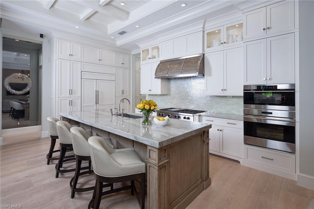 453 Spinnaker Drive Naples, FL 34102 - Photo 3 of 14 a kitchen with stainless steel appliances a table chairs and a refrigerator