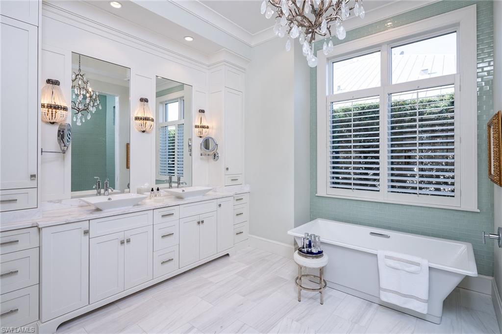 453 Spinnaker Drive Naples, FL 34102 - Photo 6 of 14 a bathroom with a granite countertop sink mirror and a bathtub next to a window