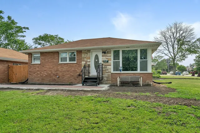 a view of a house with a yard and sitting area