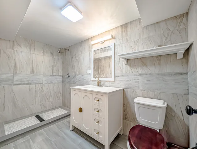 a spacious bathroom with a toilet a sink and mirror